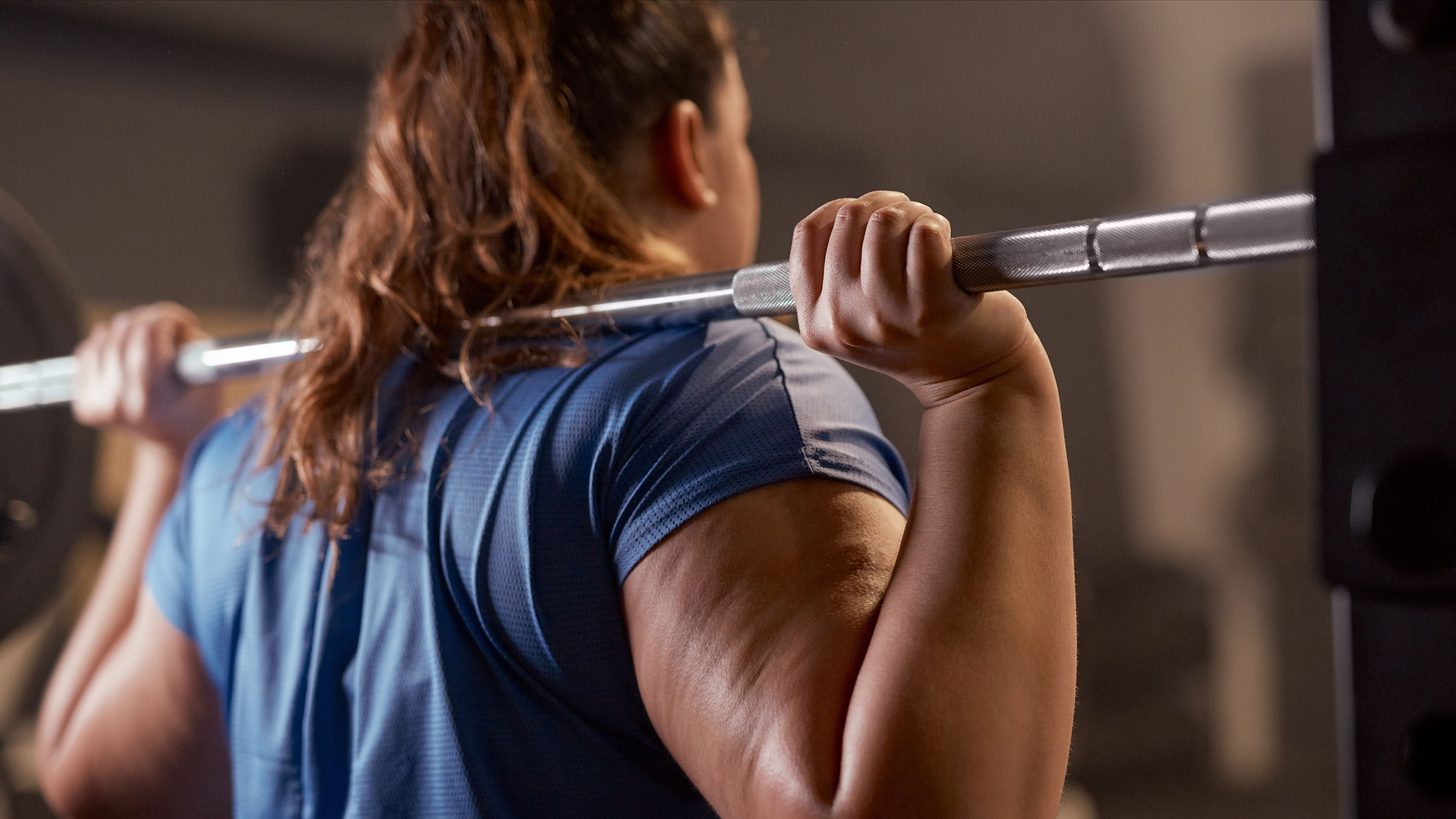 Woman holding barbell on shoulders